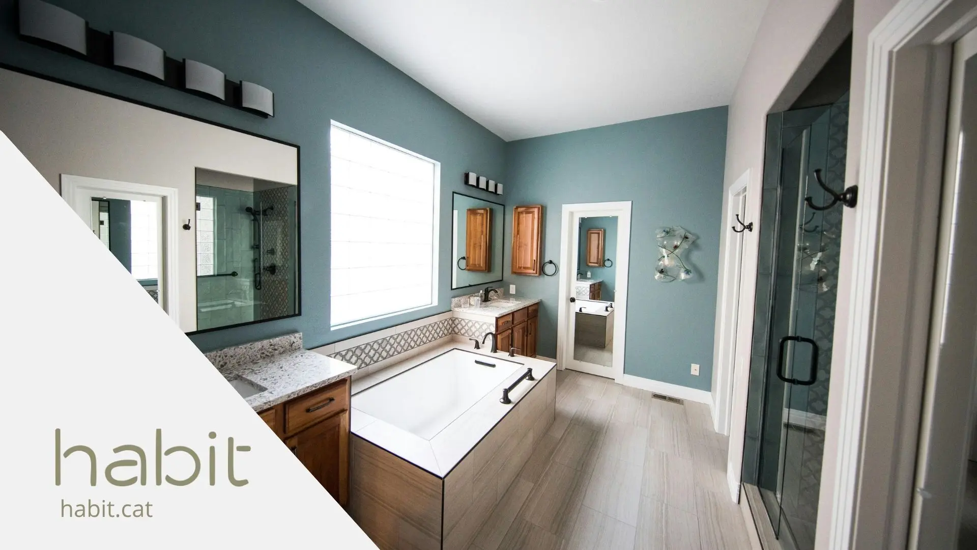 baño amplio con suelo de madera y paredes azules utilizada como fondo de un blog de Hubit